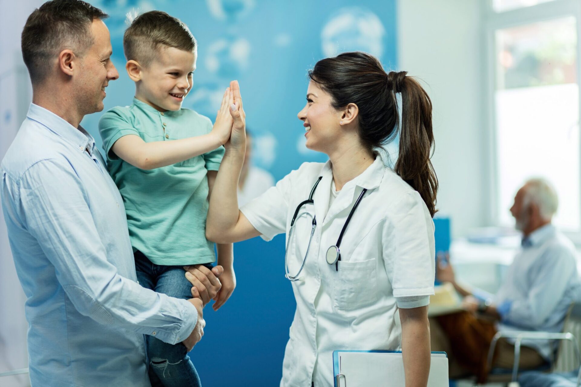 happy-female-doctor-giving-high-fie-little-boy-who-came-with-father-hospital